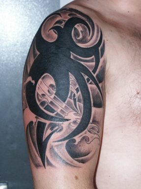 Shoulder tattoo with black tribal sign