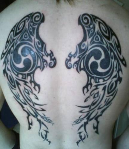 Tatuaje negro las alas con la ornamentación tribal en la espalda