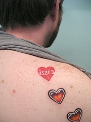 el tatuaje de tres corazones rojos hecho en la espalda