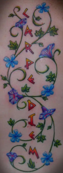 Bonito tatuaje ne color la vid con las flores azules y una inscripción