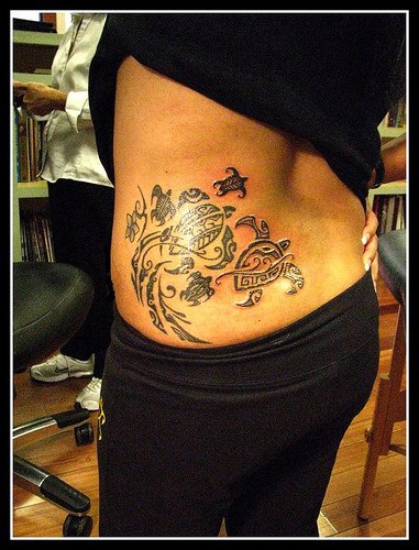 Großes schwarzes Tattoo mit Schildkröte am unteren Rücken