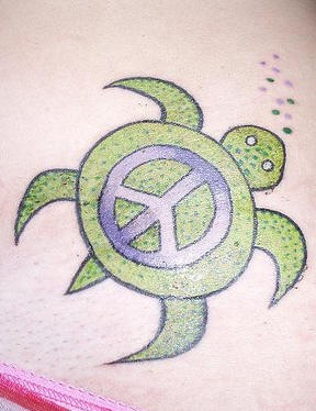 Tatuaggio colorato la tartaruga verde con il segno di pace