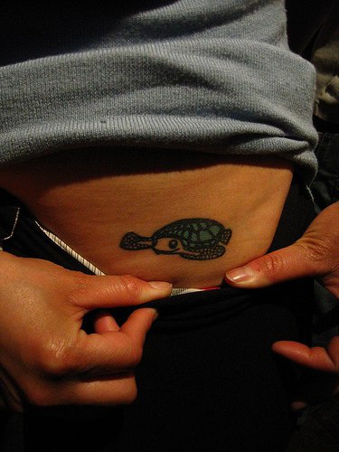 Tattoo mit kleiner grüner Schildkröte an der Seite