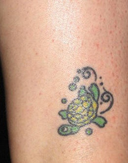 Happy small green turtle tattoo