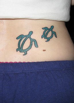Lower back tattoo with two green turtles