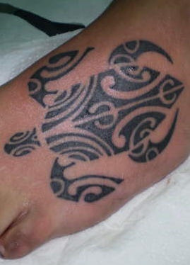 Foot tattoo with black tribal turtle