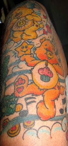 Tattoo vom süßem Bärchen, der seinen Geburtstsg feiert, am Arm
