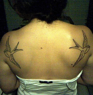 Swallows tattoo flying in two sides on upper back