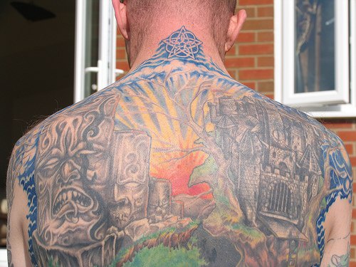 Tattoo mit Stadt aus lebendigen Steinen am oberen Rücken