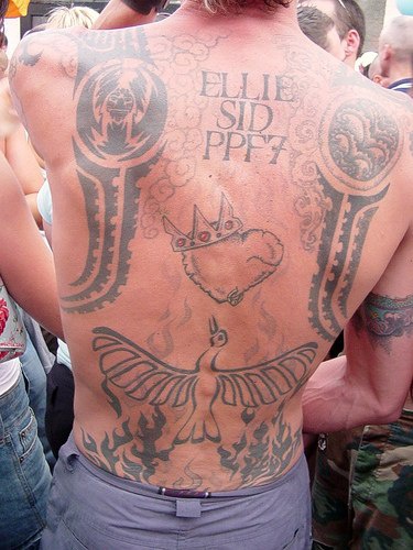 On upper back crowned heart and fireing bird tattoo