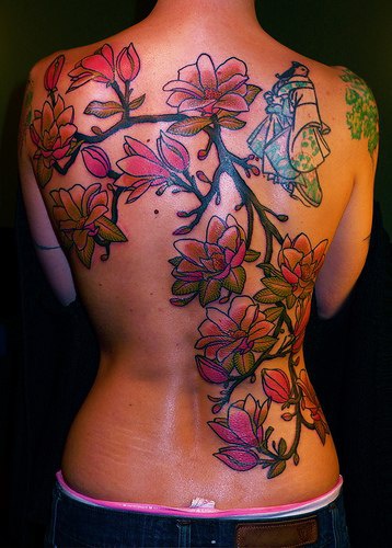 Tattoo von Geisha und charmante Blüte am oberen Rücken