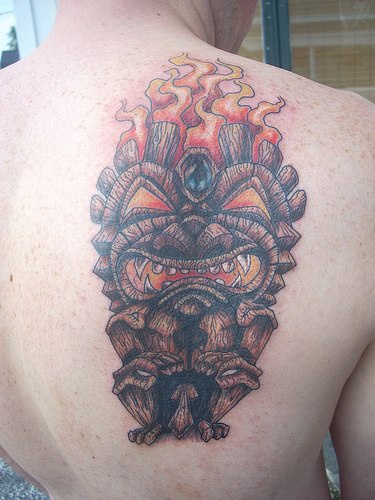 Le tatouage de haut du dos avec un torche de bois monstrueux en flammes