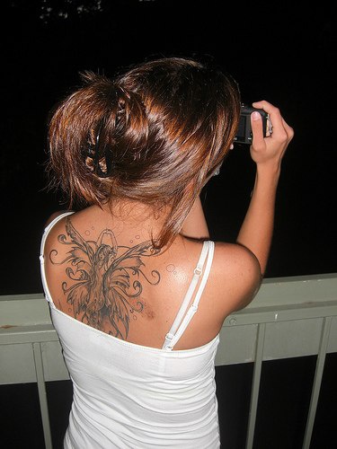 Tattoo dancing fairy with wide wings on upper back
