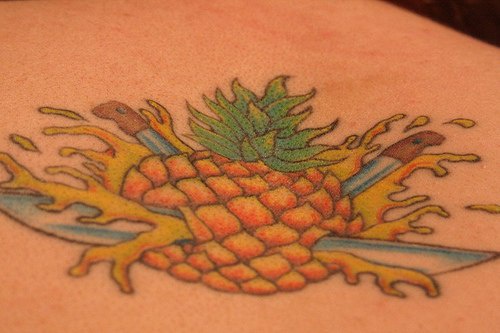 On upper back pine-apple tattoo  punctured with knives
