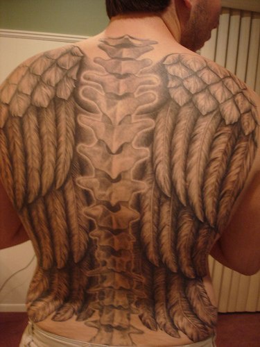 Backbone  tattoo on upper back with wide wings