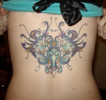 Heart tattoo  with many curls on upper back