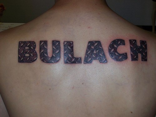 Bulach on upper back with black letters tattoo