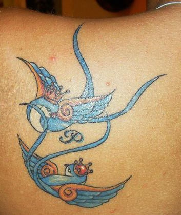 Uccelli azzurri innamorati con le corone tatuati sulla spalla