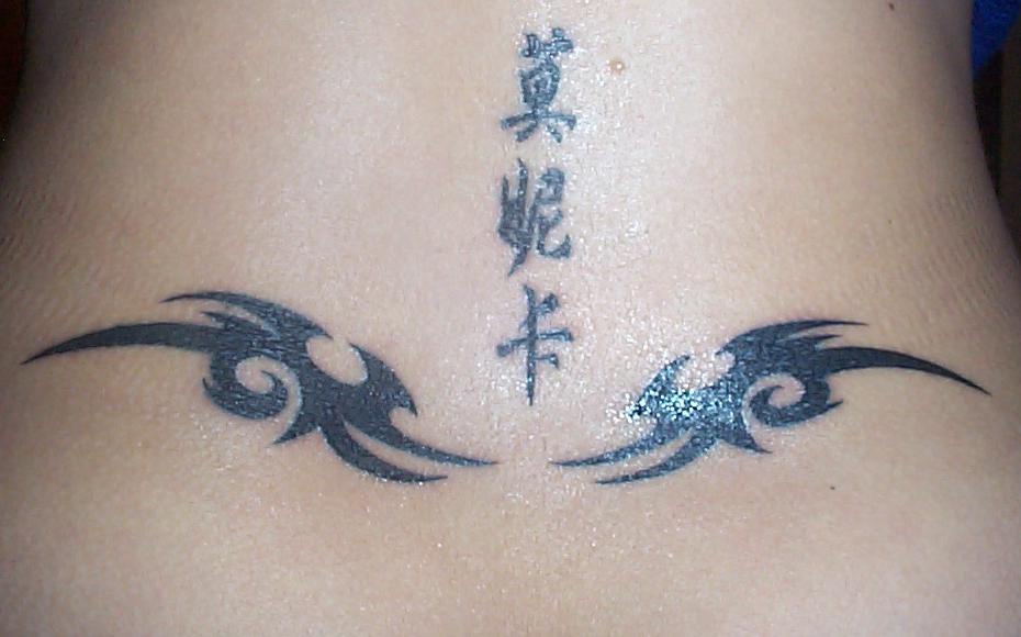 Tribal tattoo with hieroglyphs on tail base