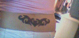 Blaßes  weibliches Tattoo am unteren Rücken