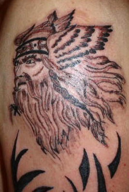 Tatuaje el viking con el pelo largo y con las alas en su casco