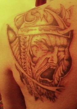 Viking guerrero gritando el tatuaje en el omopláto