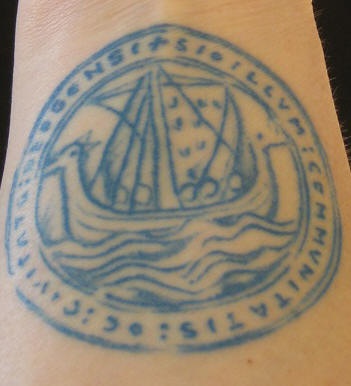 Tatuaje en tinta azul la nave de los vikings en el círculo