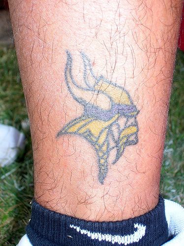 Small viking head tattoo on leg
