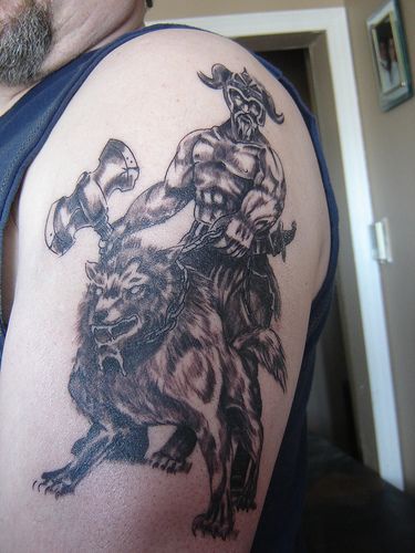 Tattoo of viking warrior with axe on wolf