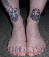 Tattoo of two vikings heads on the legs