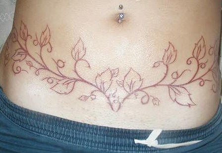 Tattoo mit roter Rebe am Bauch