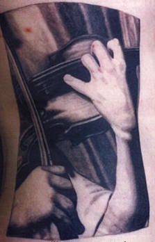 el tatuaje de una foto con un tocador del violin hecho en blanco negro