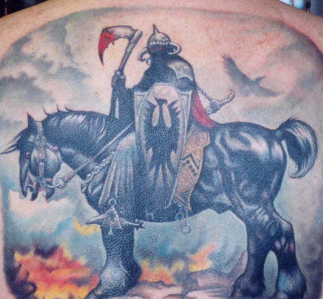 Tatuaje del guerrero a caballo con la hacha sengrienta en las manos en la espalda