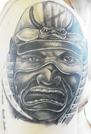 Warrior and small demon head on tattoo