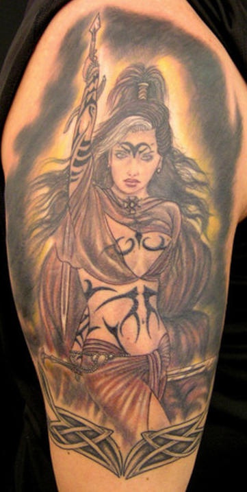 Tatuaje la guerrera desnuda con los signos tribales en el cuerpo