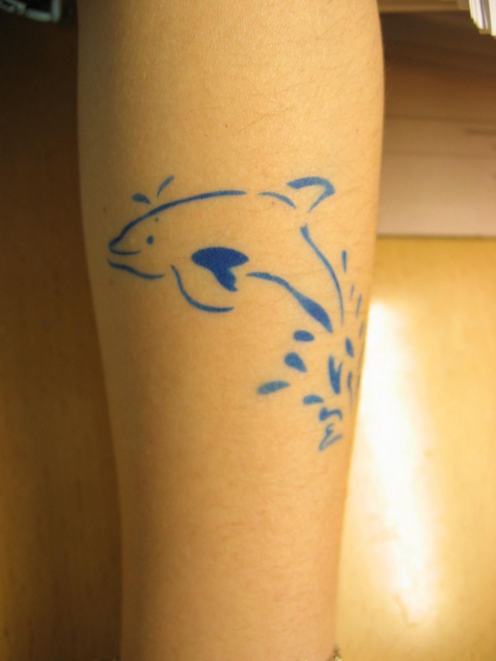 Simple tatuaje el delfín azul en el agua
