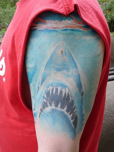 Tattoo with big shark in blue color on shoulder
