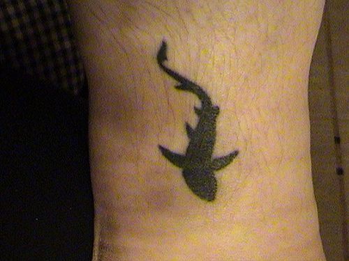 Water animal tattoo with all black floating shark