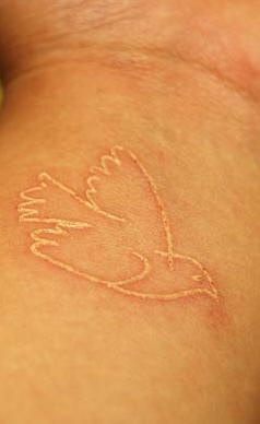 Weiße Tinte Tattoo mit Vogel am Handgelenk