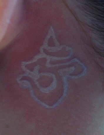 White ink tattoo with yoga sign om