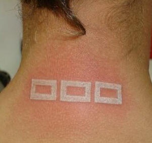 White ink tattoo with quadrates on back neck