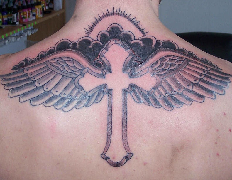 tatuaje en la espalda de cruz con alas en el cielo