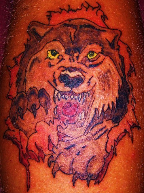 Red angry wolf with yellow eyes tattoo