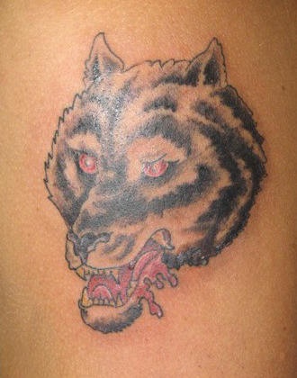 Loup noir irrité aux yeux rouges le tatouage
