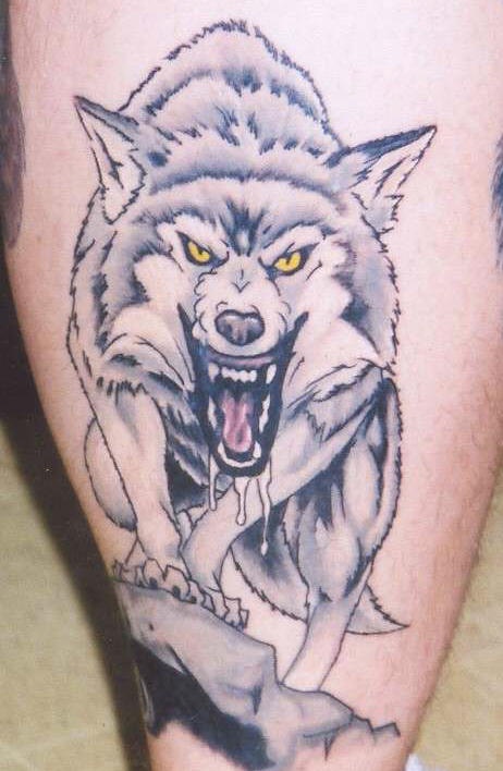 Angry wolf on the rock tattoo