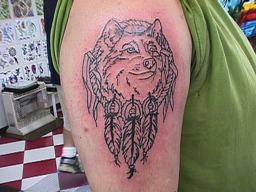 Tatuaggio non colorato sul deltoide la testa del lupo indiano