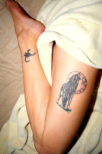 Heulender Wolf mit einem Kreis Tattoo am Bein