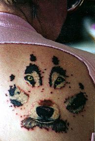 Tattoo mit Wolfs Schritt und Augen mit Mund auf ihm