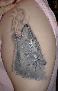 Tattoo with silver wolf on the shoulder