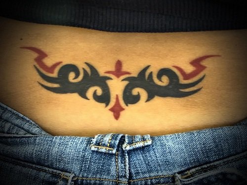 Tatuaje femenino en el bajo de la espalda, en negro y rojo